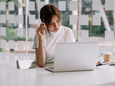 Woman thinking while looking at laptop computer